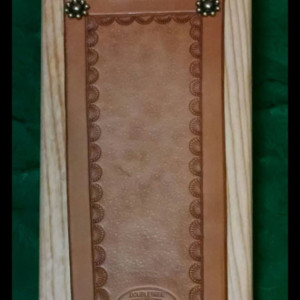 Handmade wooden boot jack with leather panel.