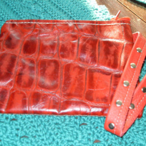 Red leather alligator print clutch purse with 2 inside lamb skin pockets and a wrist strap