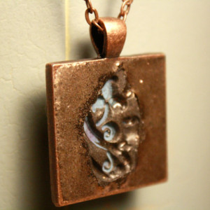 Light blue flower imprinted into copper pendant with necklace