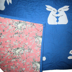 Baby Crib Quilt with White Rabbits on a Blue Background