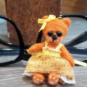 Tiny wool felted orange miniature teddy bear in a yellow sundress