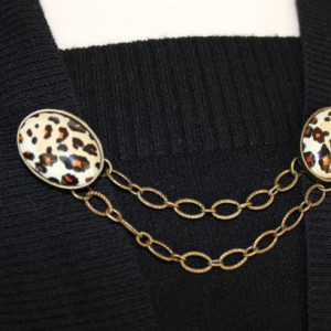 Sweater keeper with two bronze leopard cameos connected by two small bronze chains