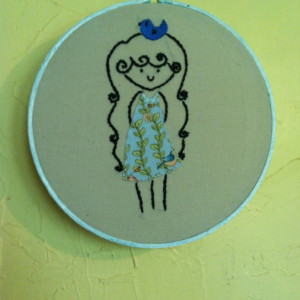 Hoop art embroidery. A girl with a bluebird on her head