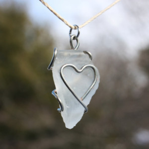 White triangle sea glass pendant with a wire heart on a white hemp cord