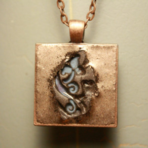 Light blue flower imprinted into copper pendant with necklace