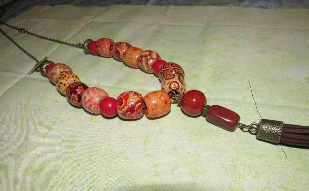 Fun wood beads with antique gold chain and tassel. 