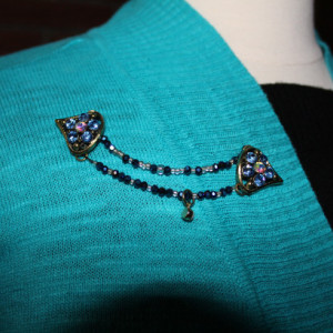Chevron shaped sweater keeper with cobalt blue glass beads and multi-colored rhinestones