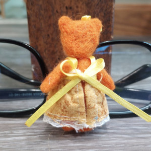 Tiny wool felted orange miniature teddy bear in a yellow sundress