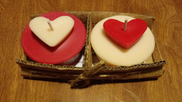 Two 3.5 oz round red and white handmade soy wax candles with inset heart on top