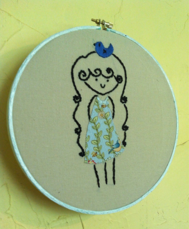 Hoop art embroidery. A girl with a bluebird on her head