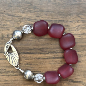 Bracelet with dark Red Sea Glass beads, clear quartz crystal beads, sterling silver toggle, beads and findings. 8.50” Length 
