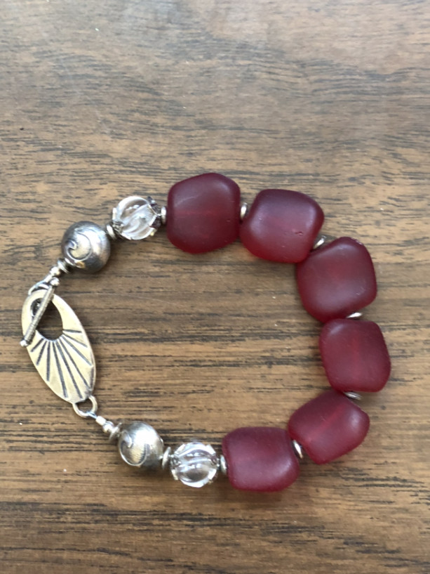 Bracelet with dark Red Sea Glass beads, clear quartz crystal beads, sterling silver toggle, beads and findings. 8.50” Length 
