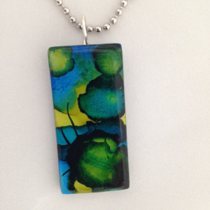 Alcohol ink painted glass pendant. Blue, green, black and gold